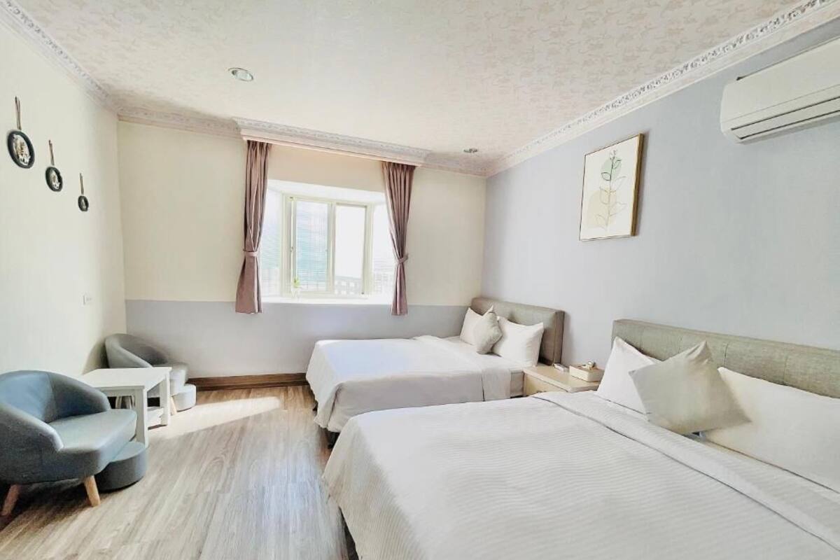 Habitación de hotel con dos camas, un escritorio y una silla.
