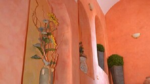 Una escalera con pared rosa y un florero a la izquierda.