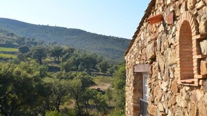 A stone building with a balcony overlooking a hilly landscape with trees. - Hameau des Claudins (Plan-de-la-Tour)