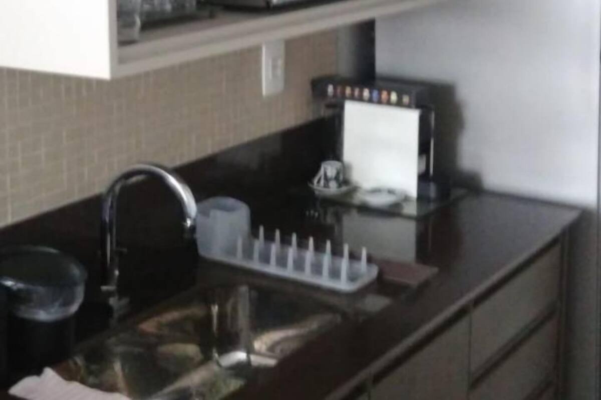 A kitchen with a microwave, coffee maker, and a stainless steel refrigerator.