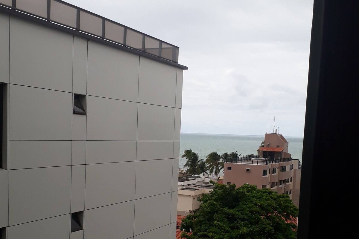 A modern building with a grid-like facade and a rooftop terrace.