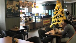 A restaurant interior with a Christmas tree, tables, chairs, and a counter with a menu. - Holanda's Prime - Praia de Tambaú (João Pessoa)