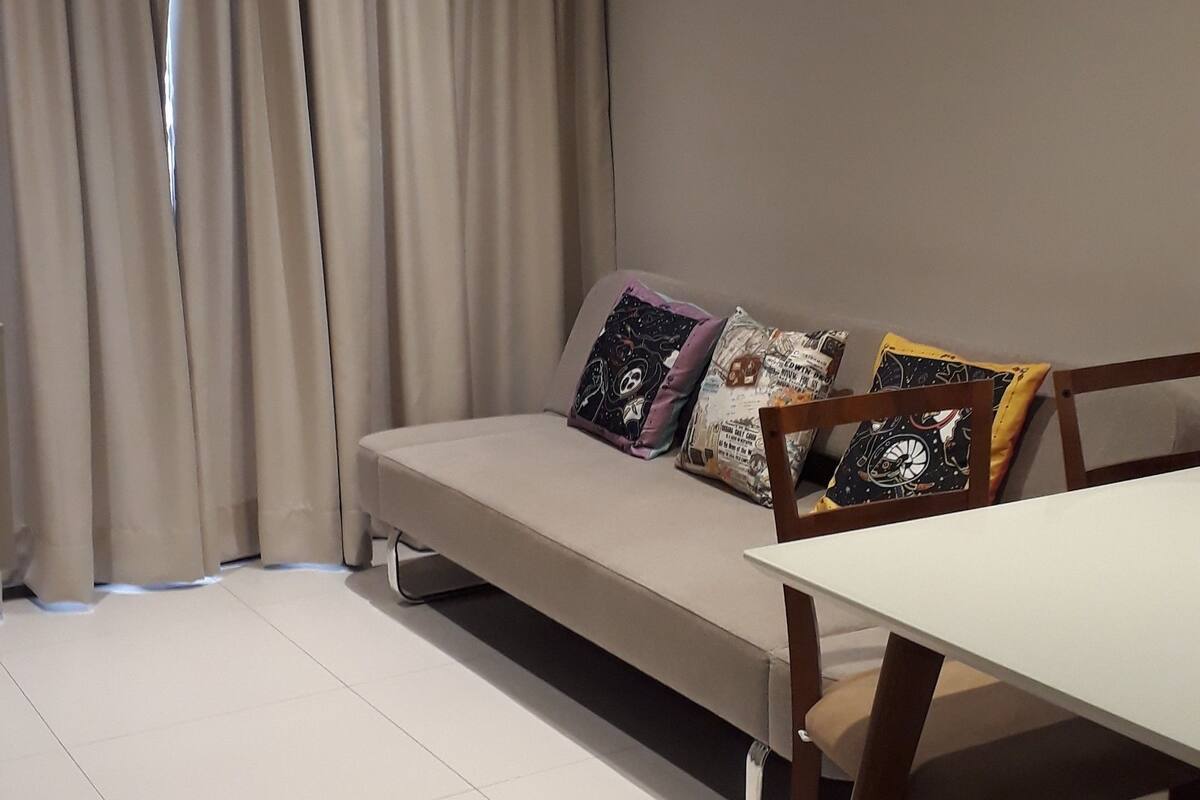 A modern living room with a sofa, a dining table, and a chair.