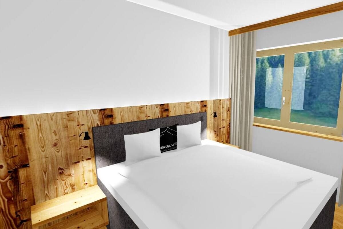 A modern bedroom with a wooden headboard, a large bed, a nightstand, and a window with curtains.