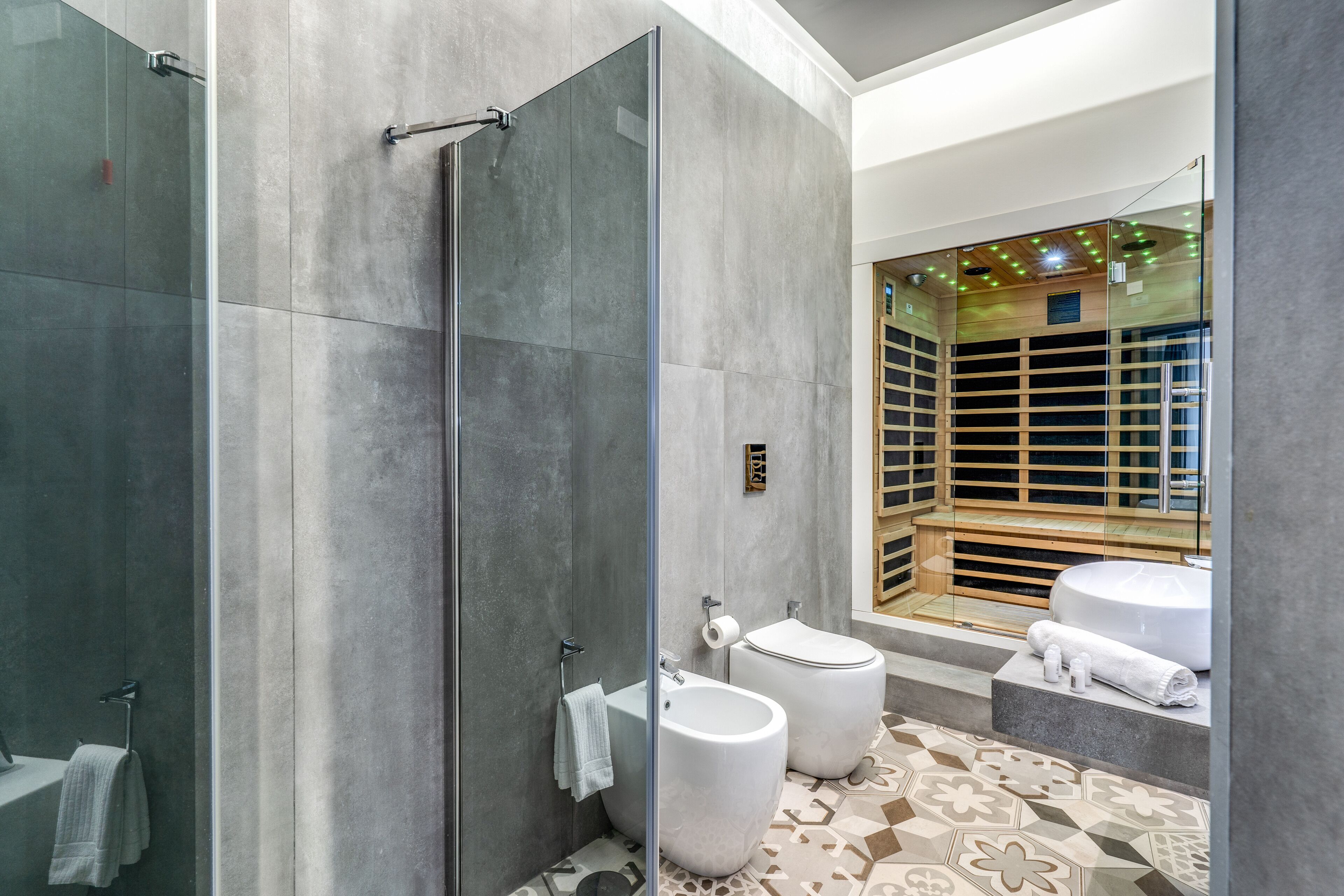 Un bagno moderno con doccia vetrata, bidet e vasca da bagno.
