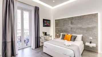Une chambre d’hôtel moderne, dotée d’un grand lit, d’un bureau et offrant une vue sur la ville par la fenêtre.
