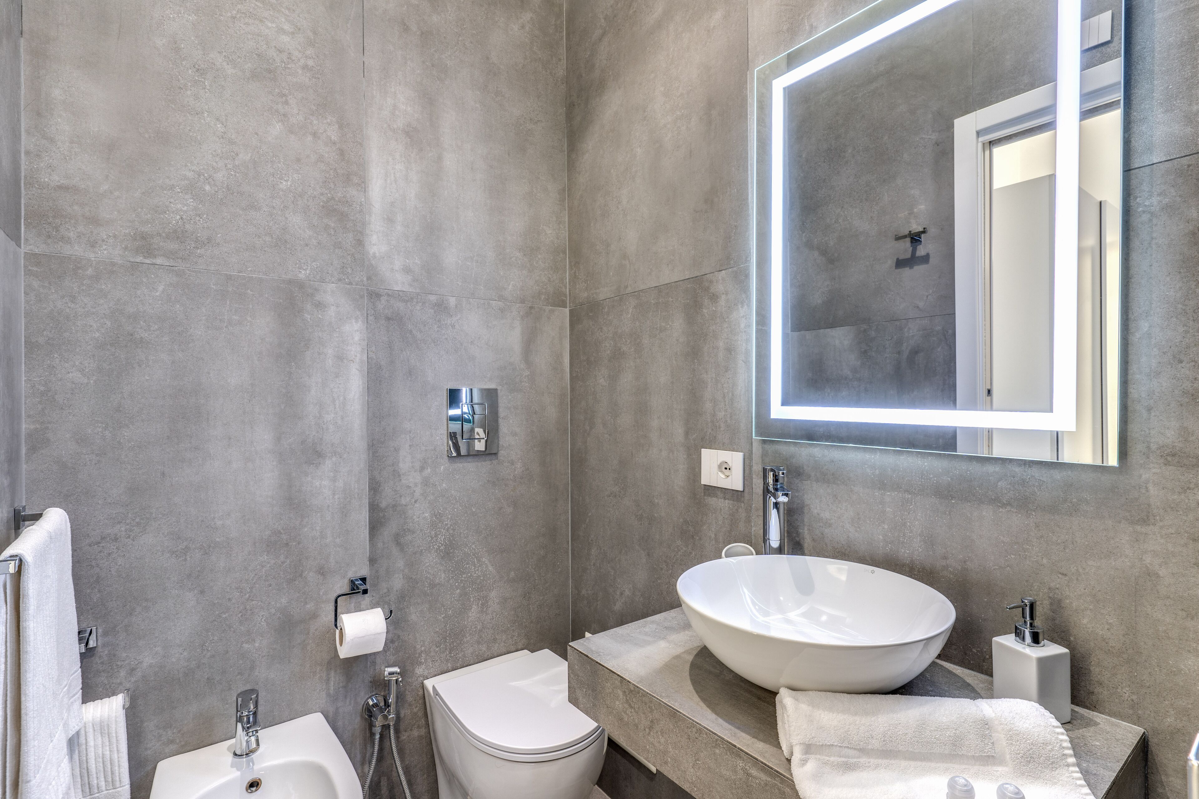 Une salle de bain moderne avec un grand lavabo, des toilettes et une douche.