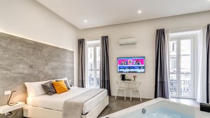 Une chambre d’hôtel moderne équipée d’un grand lit, d’une télévision, d’un bureau et d’une baignoire.