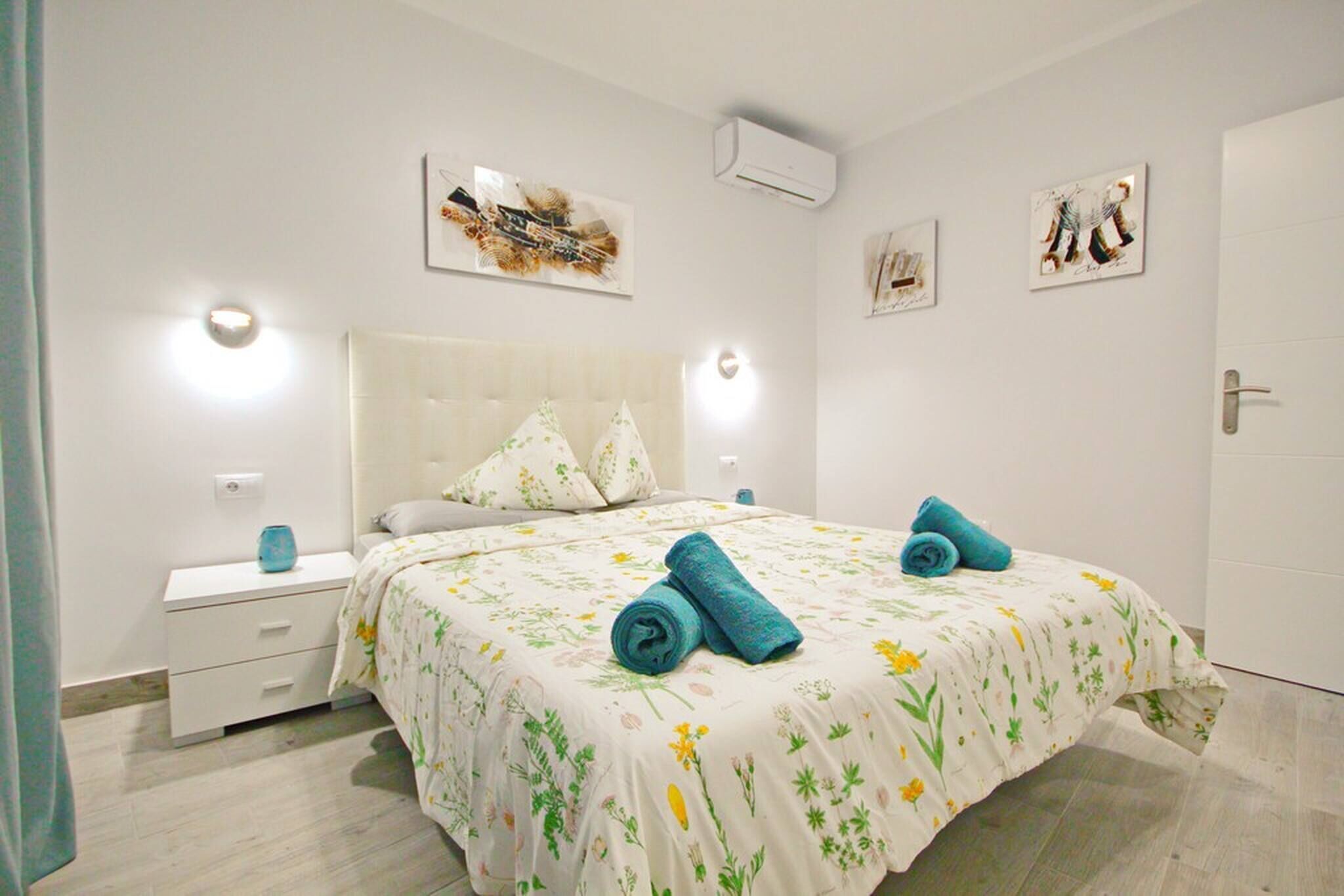 Een slaapkamer met een bed, nachtkastjes en wanddecoratie.