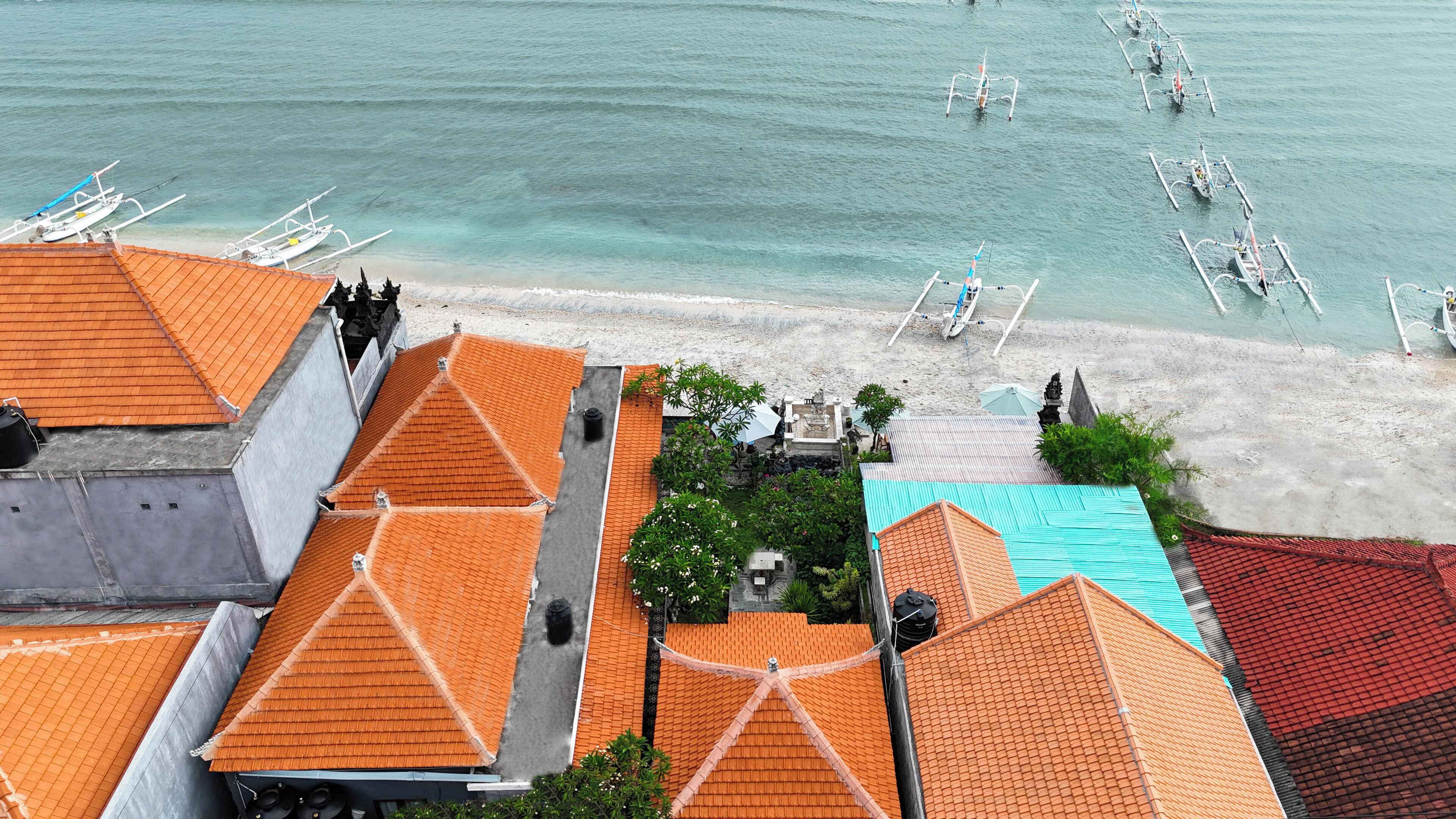 A coastal area with buildings, a beach, and boats.