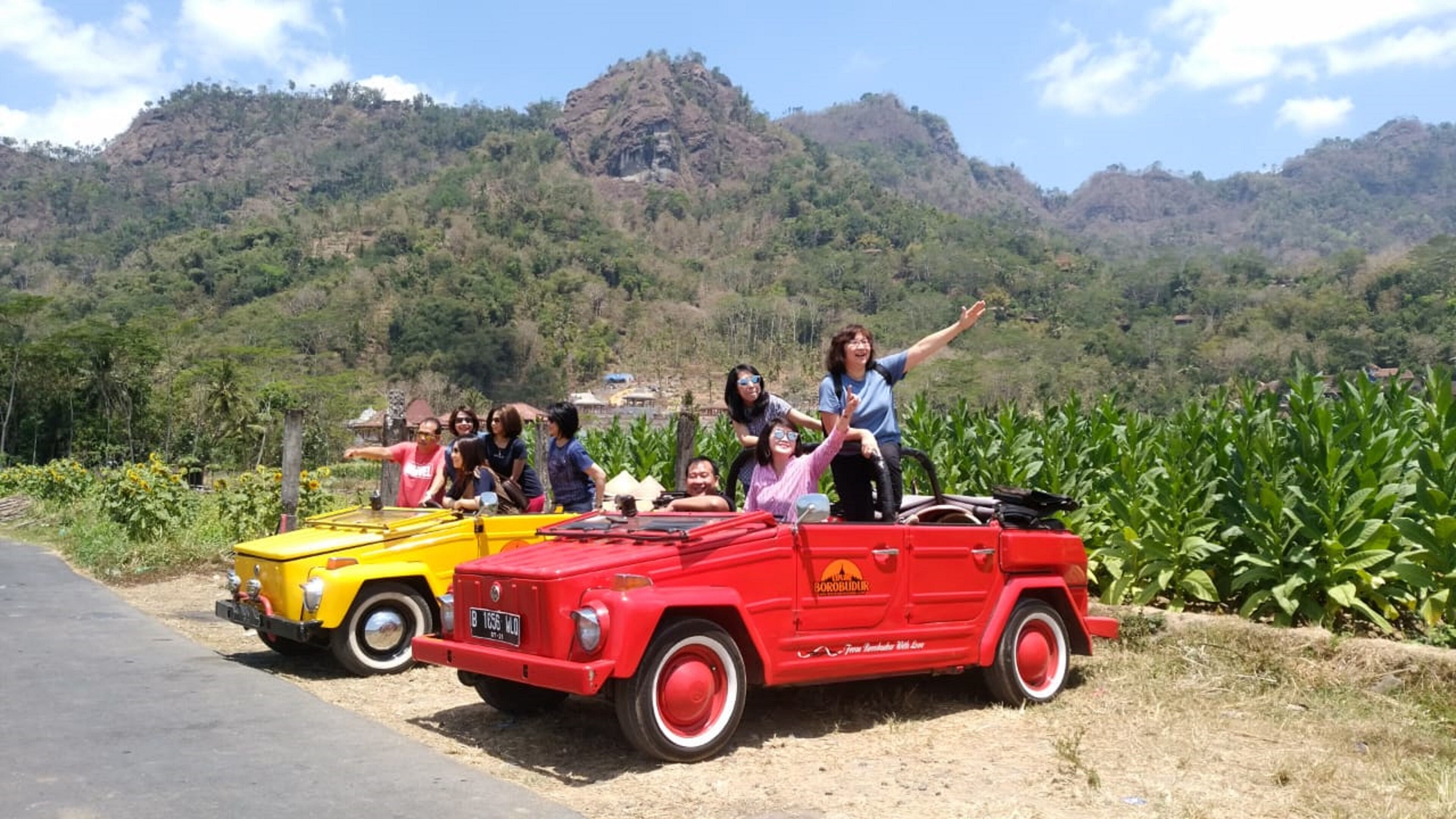 A red convertible car with passengers enjoying the ride.
