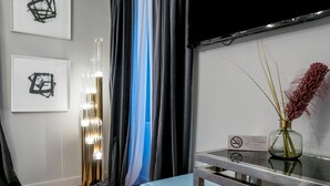 A hotel room with a modern design, featuring a large mirror, a vanity with a vase of red flowers, and artwork on the walls. - Artale 07 - Adults Only (Split)