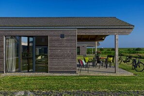 Et moderne hus med en patiohave med udendørs møbler og cykler.