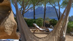 A hammock chair overlooking a lake with mountains in the background. - Villa Gaviel, private descent to lonely beach, scenic P. Istana, wifi (Porto Istana, Olbia)