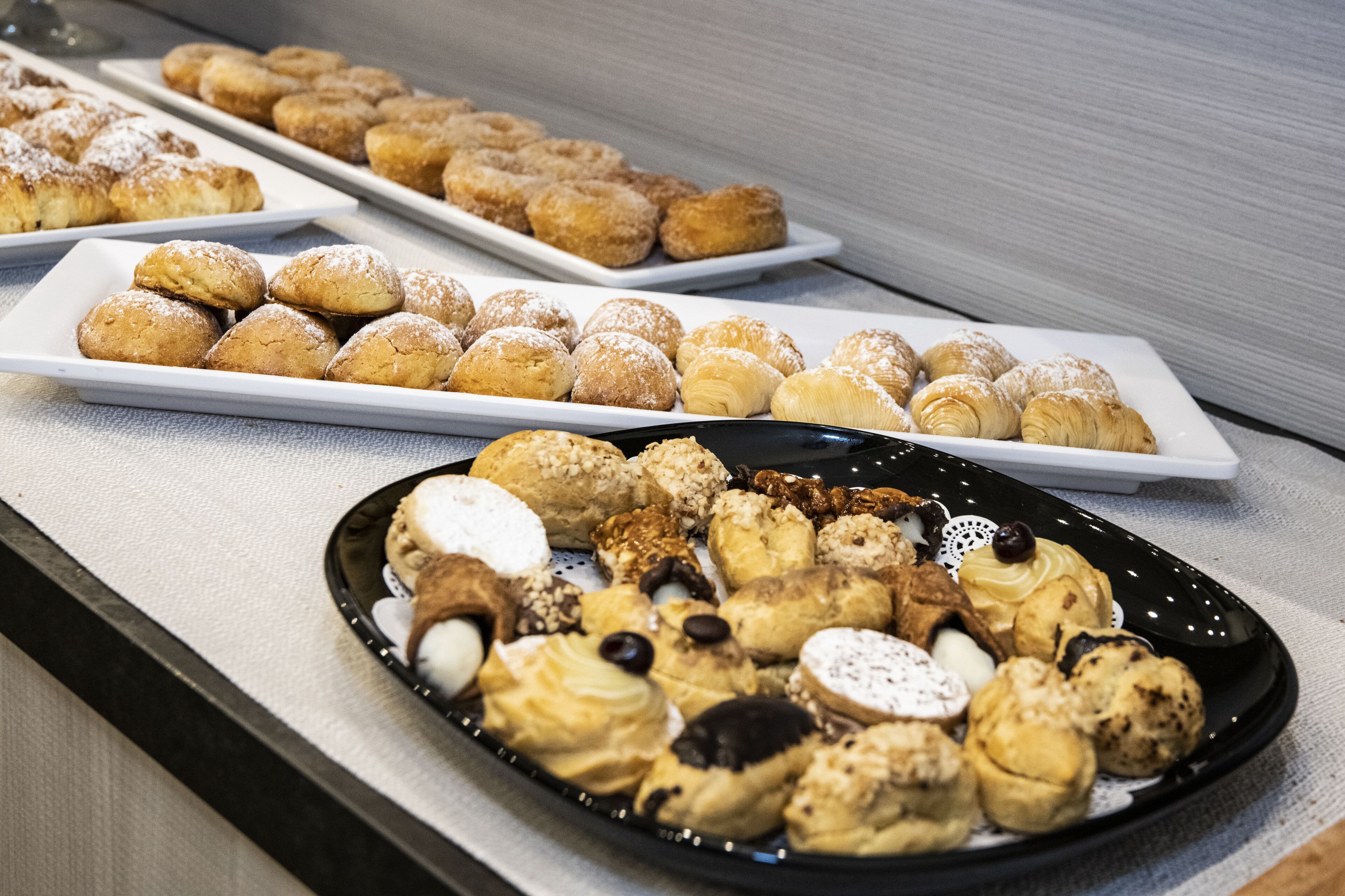 A variety of pastries and desserts arranged on plates.