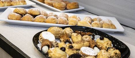 A variety of pastries and desserts arranged on plates.