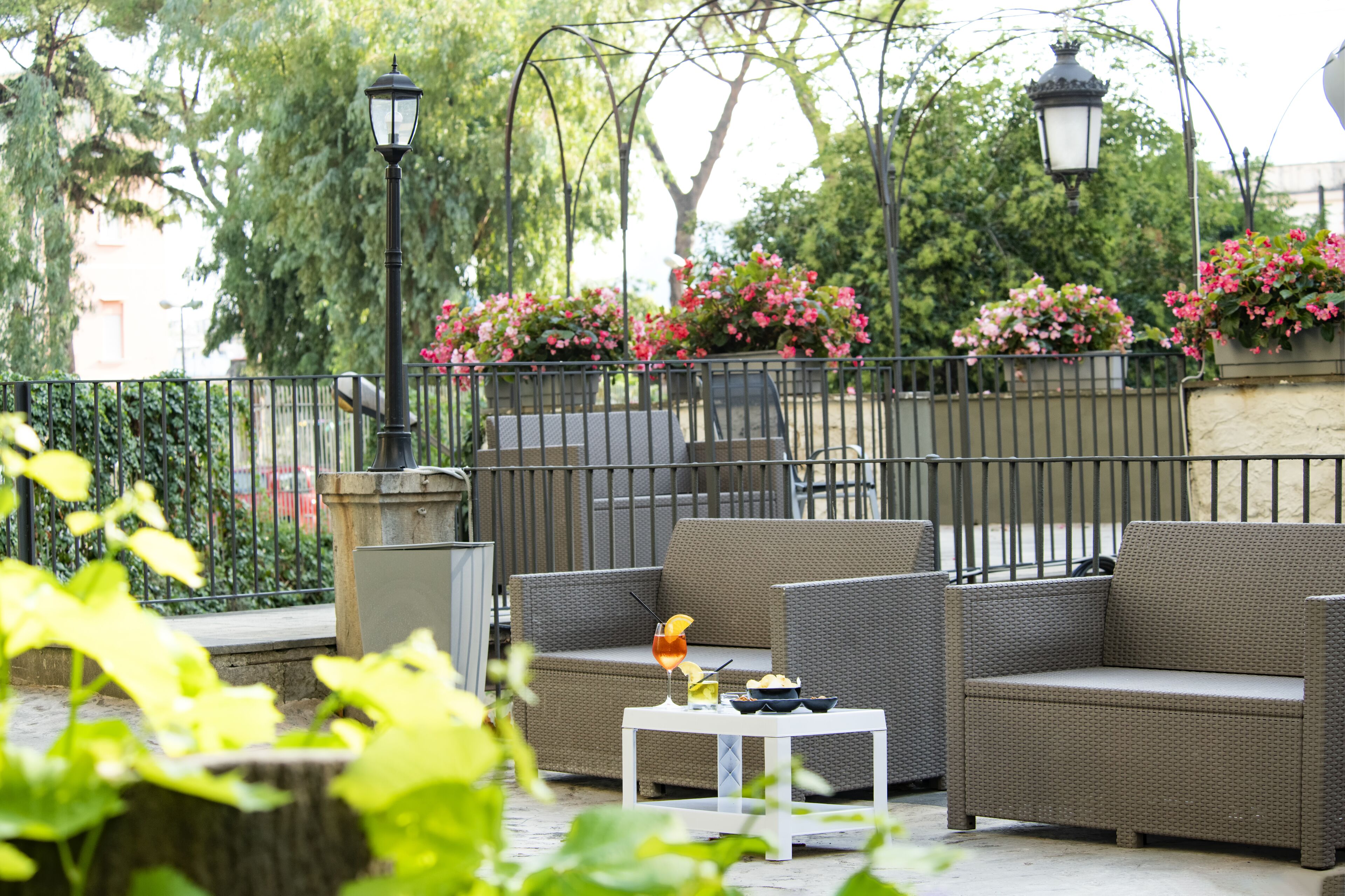 An outdoor seating area with wicker furniture and a small table with a drink and snacks.