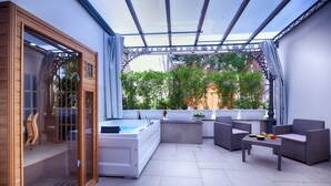 A spa area with a hot tub, seating, and a view of greenery. - Villa Elisio Hotel & Spa (Naples)