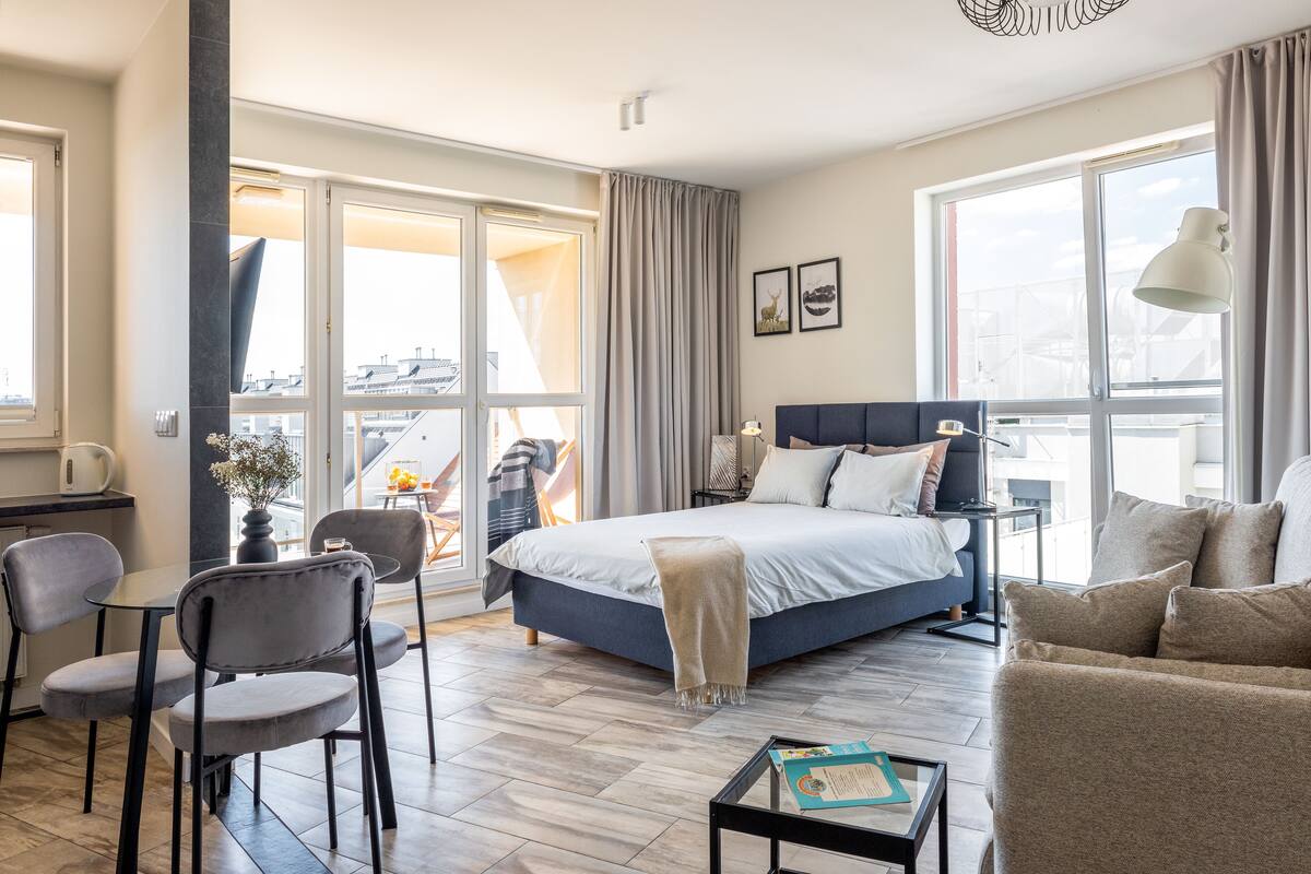 Ein modernes Hotelzimmer mit einem großen Bett, einem Schreibtisch, einem Sessel und einer Couch.