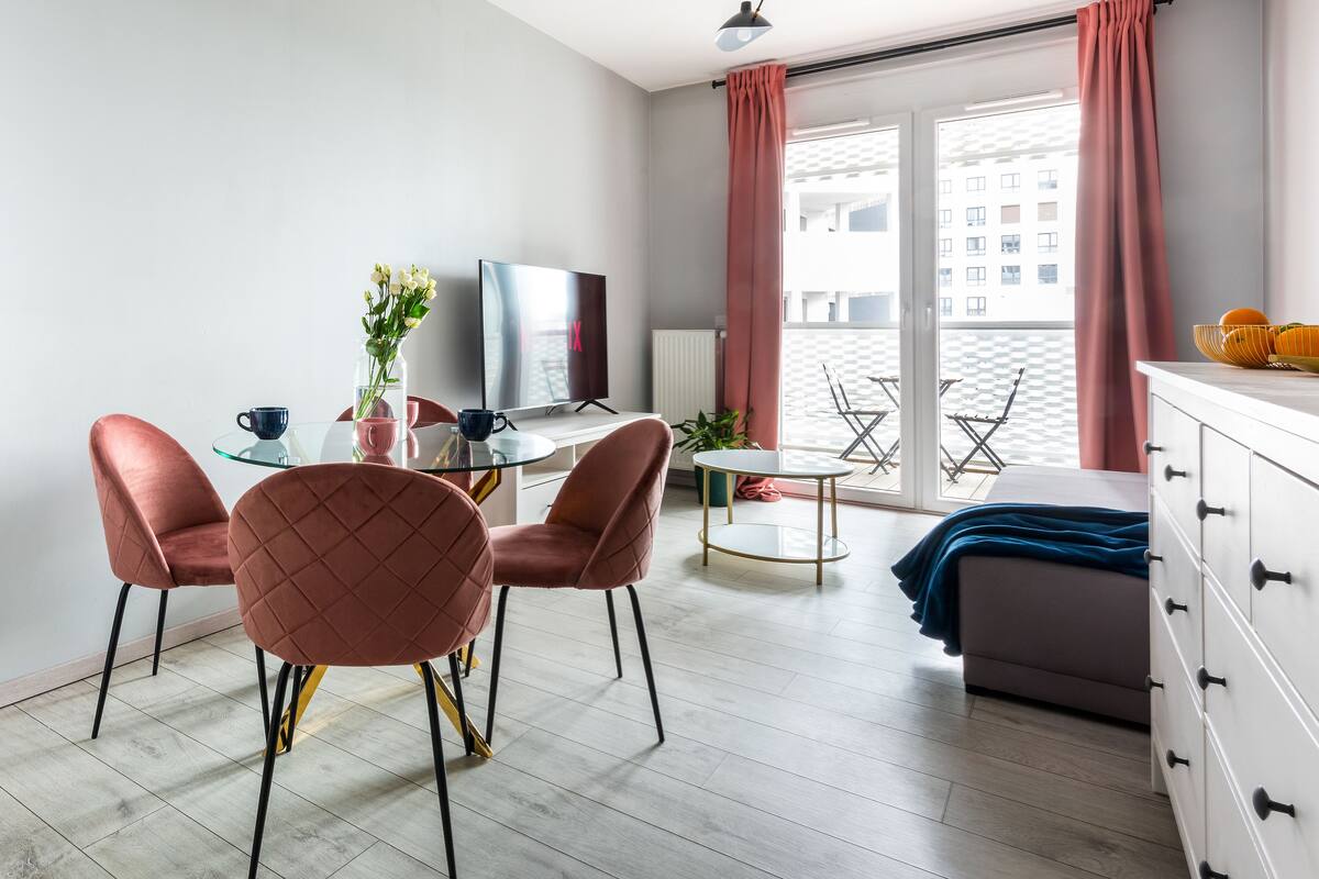 A modern room with a dining area, a bed, and a TV.