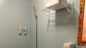 A bathroom with a toilet, a sink, a shower, and a towel rack. - Blue Pa Hotel (Hengchun)