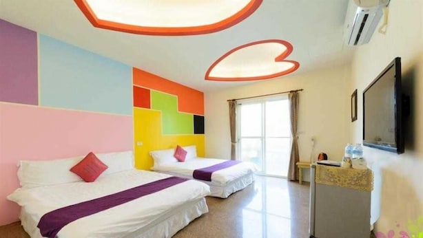 A hotel room with two beds, a TV, and a window with curtains. - Blue Pa Hotel (Hengchun)