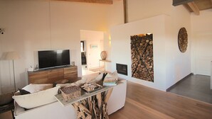 Ein modernes Wohnzimmer mit Flachbildfernseher, Holzboden und einem einzigartigen Couchtisch aus einem Baumstumpf.