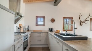 Eine moderne Küche mit einer zentralen Kochinsel, einem Spülbecken und einer Uhr an der Wand.