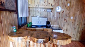 Eine rustikale Küche mit Holzschränken, einem Herd und einer Bar mit Hockern.
