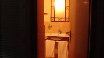 A bathroom with a sink, mirror, and two towels hanging on a rack.
