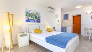A modern bedroom with a bed, bedside tables, a desk, and a chair. - Guest House Kovacevic (Hvar)