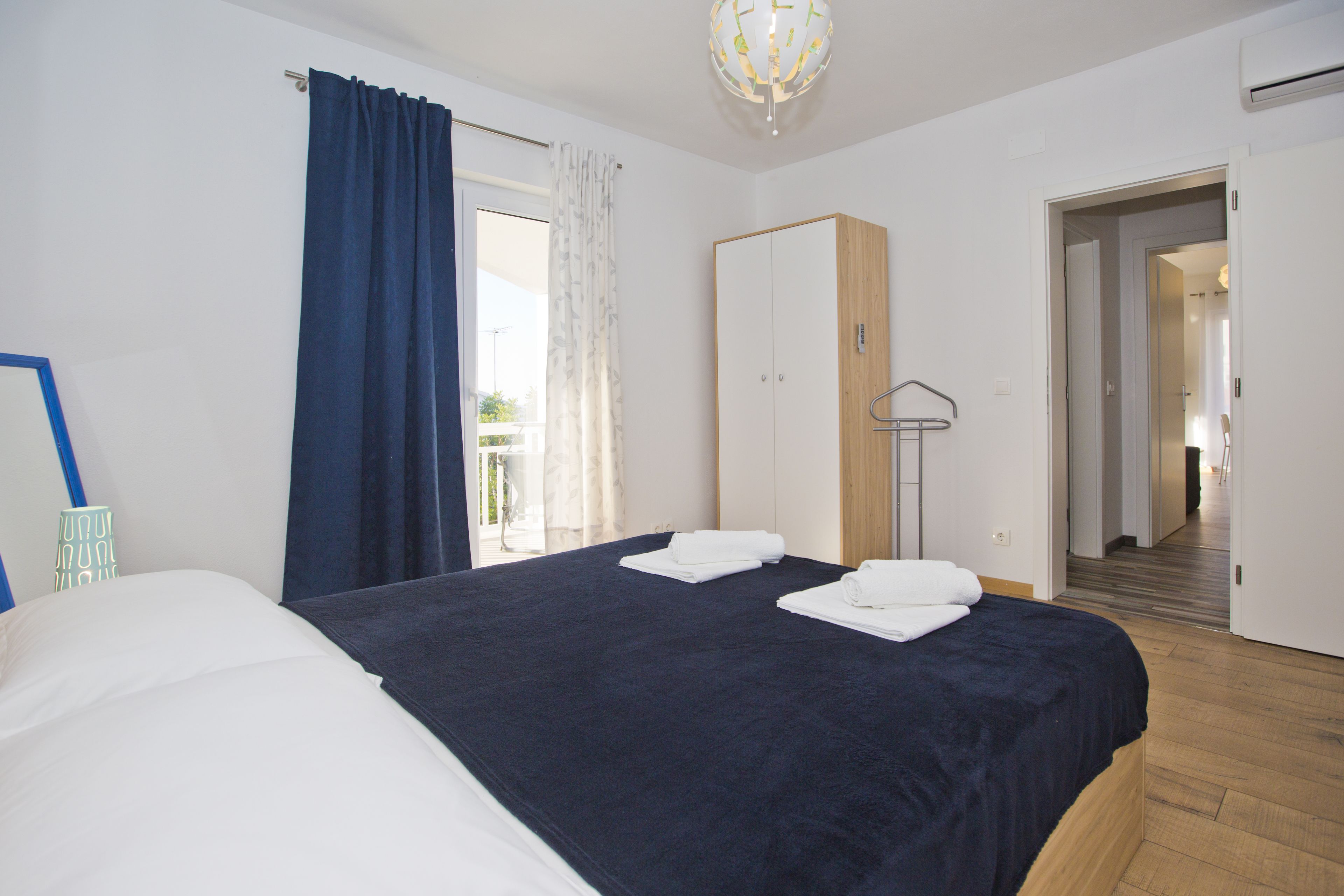 A bedroom with a bed, a wardrobe, and a bathroom visible through an open door.