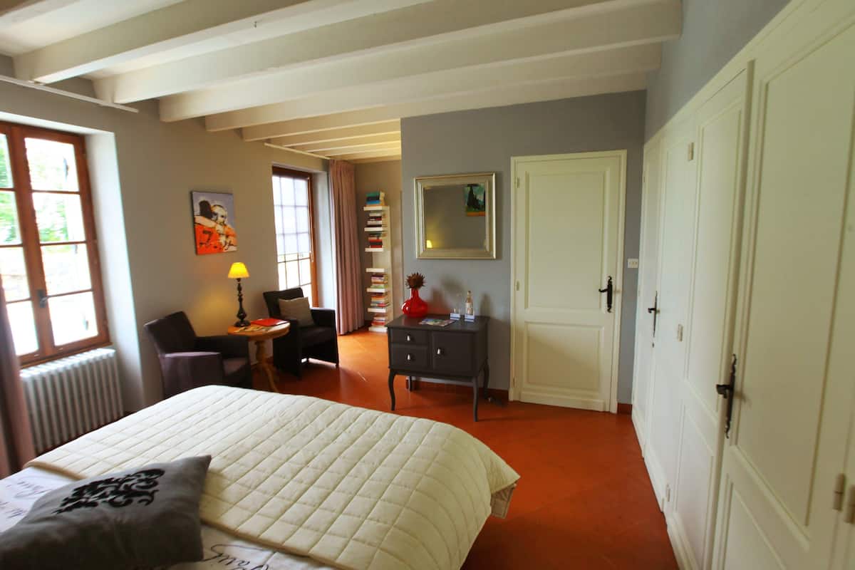Ein Schlafzimmer mit Bett, Schreibtisch, Stuhl, Bücherregal und einer Tür.