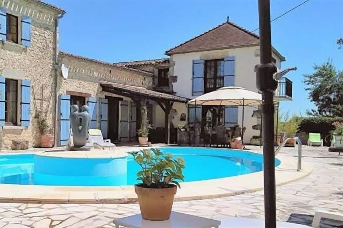 Ein Innenhof mit Swimmingpool, Steinbauten und Gartenmöbeln.