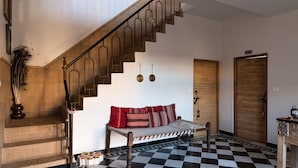 A staircase with a checkered floor, a wooden bench with red cushions, and a door labeled "TRA". - The Secret House - Adults Only (Jaisalmer)