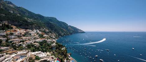 A coastal town with buildings along the hillside and a marina with boats.