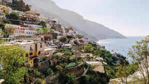 A coastal village with terraced houses, a clear view of the sea, and a mountain in the background. - Villa Anfitrite (Positano)
