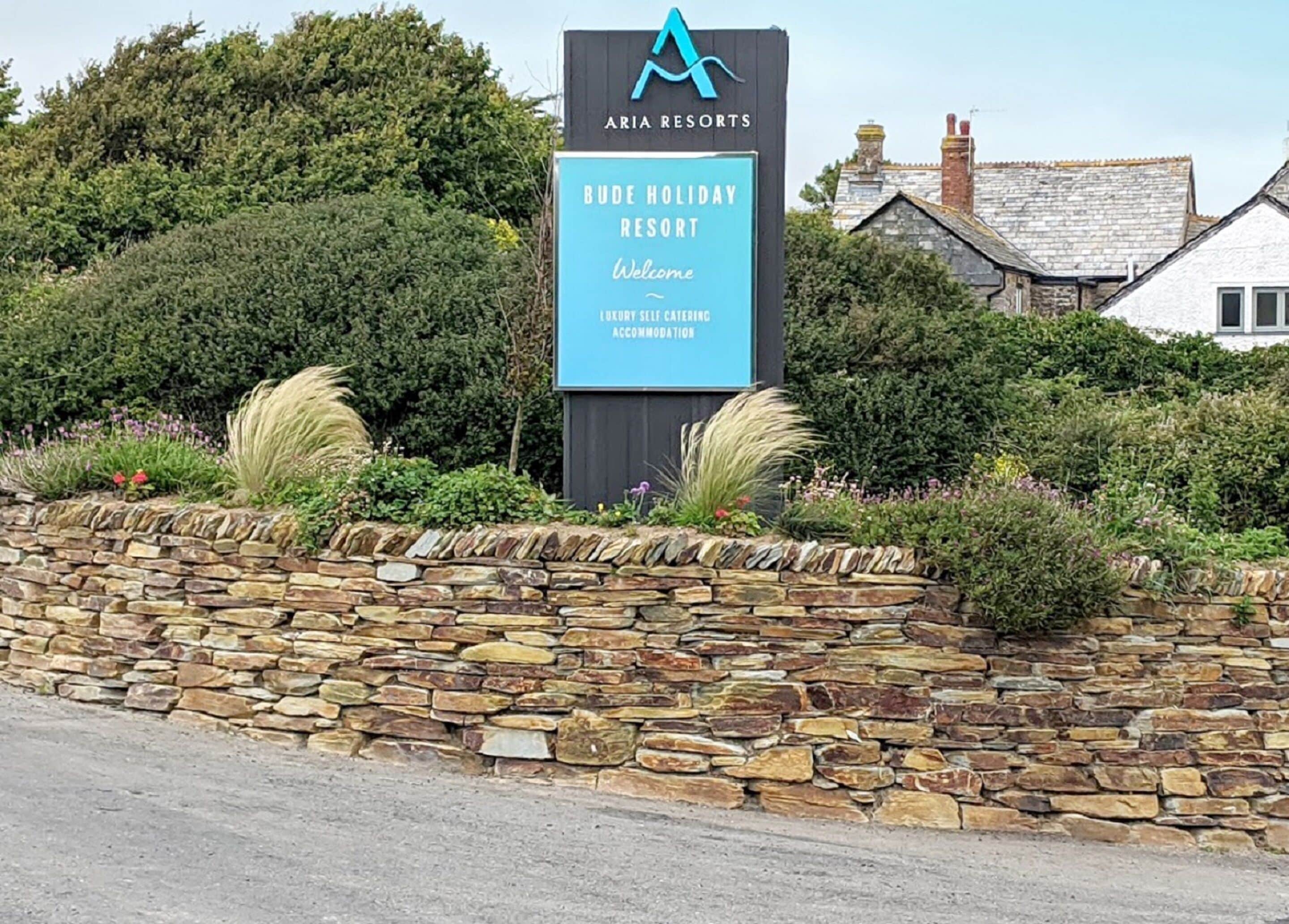 Schild für den Ariya Resorts Bude Holiday Resort, das luxuriöse Ferienwohnungen bietet.