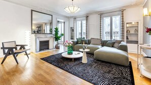 A modern living room with a fireplace, a sofa set, a coffee table, and a large mirror.