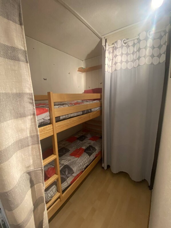 A bunk bed room with a curtain and a butterfly decal on the wall. - T2 ground floor apartment with terrace (SAINT PIERRE LA  MER)