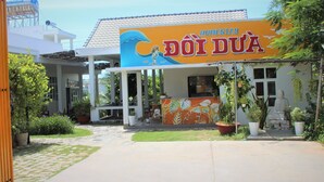A building with a sign reading "HOMESTAY DOIDUA". - Doi Dua Homestay (Mui Ne)