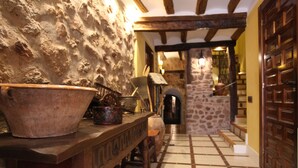 A rustic interior with a stone wall, wooden counter, and a tiled floor. - La Casa de Lucas (Clavijo)