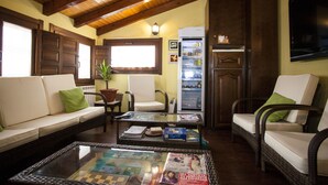 A cozy living room with a sofa, two armchairs, a coffee table with magazines, a refrigerator, and a television mounted on the wall. - La Casa de Lucas (Clavijo)