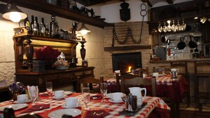 A cozy restaurant with checkered tablecloths, wooden furniture, and a brick fireplace. - La Casa de Lucas (Clavijo)
