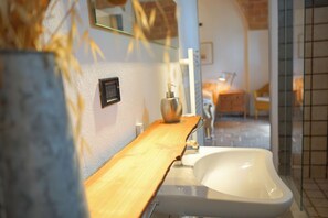 Bathroom features a sleek sink, wooden countertop, and a mirror.