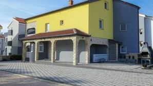 Un bâtiment jaune avec un toit en tuiles et un petit porche.