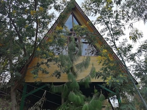 A triangular wooden structure with a large window and a cross at the peak. - Cabañas Villa Helena (Guasca)