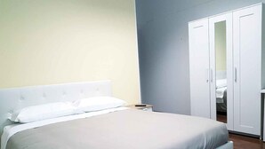 Une chambre à coucher avec un lit, une armoire et une table de chevet.