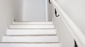 Una escalera con escalones y barandilla blancos.