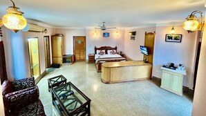 Une chambre d’hôtel avec un lit, un bureau, un canapé et une télévision.